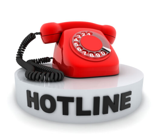 A red phone sitting on the word hotline, implying a whistleblower hotline.
